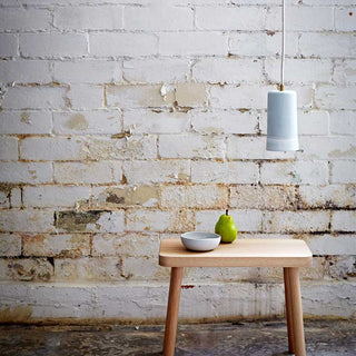Dusked Pendant light over a small wooden table with a pear and bowl.