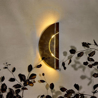 Furlcircle1 wall sconce with warm light and foliage