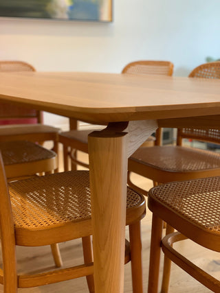 Wooden table and chairs with woven seats.
