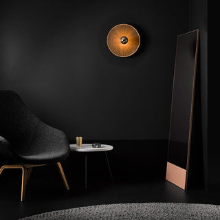 Ingeous interior with modern chair, mirror, and wall lamp.