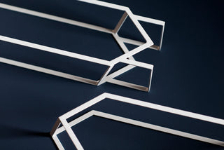 Jex-white geometric metal shapes on dark blue