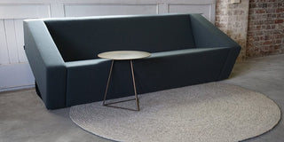 Obelisk showroom sofa with side table and rug.
