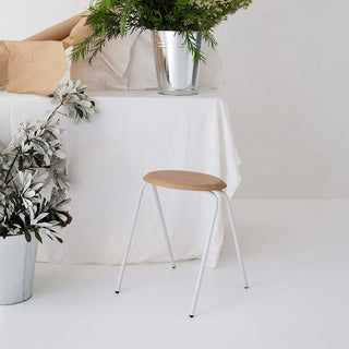 Wooden stool in minimalist interior with flowers