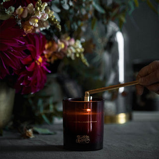 Sirens2 candle being lit with flowers in the background