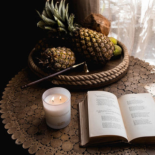 Pineapple, candle, and book on table