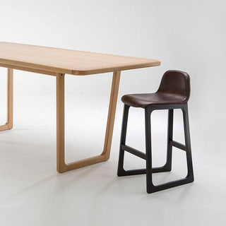 TILLER Upholstered Stool beside a wooden table