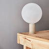 Table lamp with globe shade on wooden table