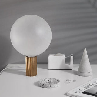 Table lamp with globe shade on desk