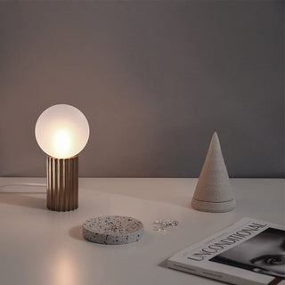 Table lamp with a globe-shaped light fixture and bronze base.