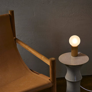 Table lamp with lit bulb on side table.