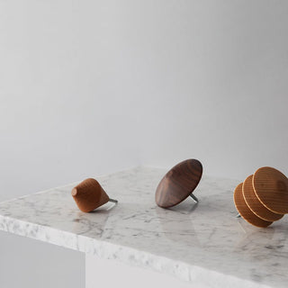 Three wooden wall hooks on marble surface