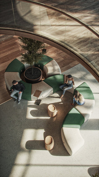 People sitting on green and white curved benches in a modern lobby.